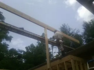 Carpenter setting a ridge beam over a new addition frame — Ice Dam Removal by Roofing Brothers in Atglen