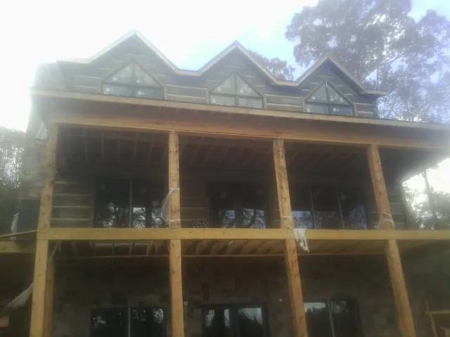 Dormers and porch framing on a large log home under construction — Roof Coating work by our crew in Atglen