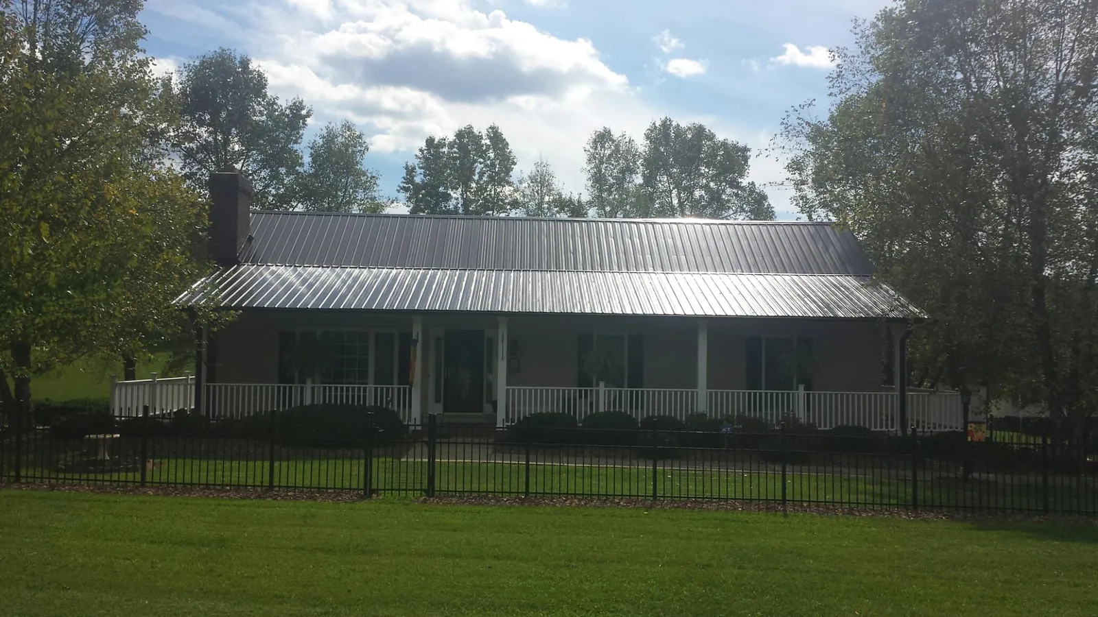 Gray metal roof on a brick ranch with a full width front porch — Gutter Guard Installation work by our crew in Atglen